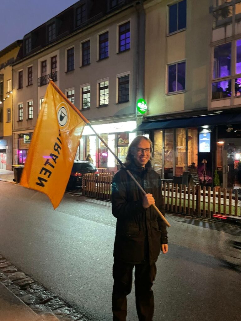 Momme Jürgens mit einer Piratenfahne in der Hand in der Dresdner Neustadt